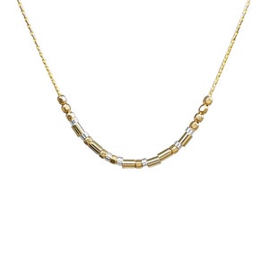 May include: A delicate gold-coloured necklace featuring small, cylindrical and spherical beads. The beads alternate between gold and silver-coloured metal. The necklace is shown against a white background.