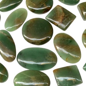 May include: A collection of polished green gemstones in various shapes including ovals, circles, and squares. Each stone features a smooth, glossy surface with natural brown and dark green inclusions, displaying unique patterns and color variations throughout.