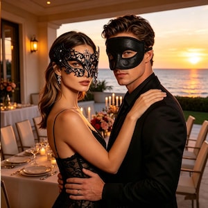 Op de afbeelding: Een stel draagt zwarte maskers en omhelst elkaar op een buitenevenement. De vrouw draagt een zwart kanten masker, de man een leren masker. De achtergrond toont een zonsondergang boven de oceaan, een tafelsetting en kaarsen.