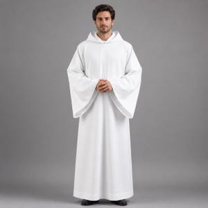 May include: A white hooded robe with wide sleeves. The robe is long, reaching the ankles, and is made of a smooth fabric. The person in the image is wearing black shoes. The background is a solid gray.