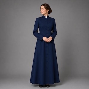May include: A long, navy blue dress with a high collar and button-down front. The dress features long sleeves and a flared skirt. A white collar is visible at the neckline. The dress is made of a smooth fabric and is suitable for formal occasions.