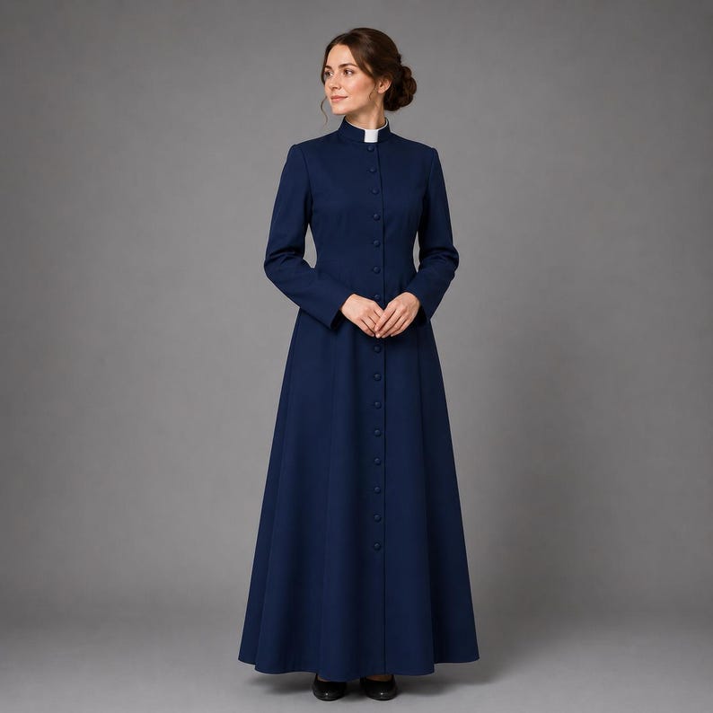 May include: A long, navy blue dress with a high collar and button-down front. The dress features long sleeves and a flared skirt. A white collar is visible at the neckline. The dress is made of a smooth fabric and is suitable for formal occasions.