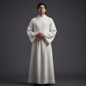 May include: A white, long-sleeved robe with a high collar and wide sleeves. A thin, cream-colored rope belt cinches the waist. The robe is floor-length and made of a soft, flowing fabric. The person is standing in front of a gray background.
