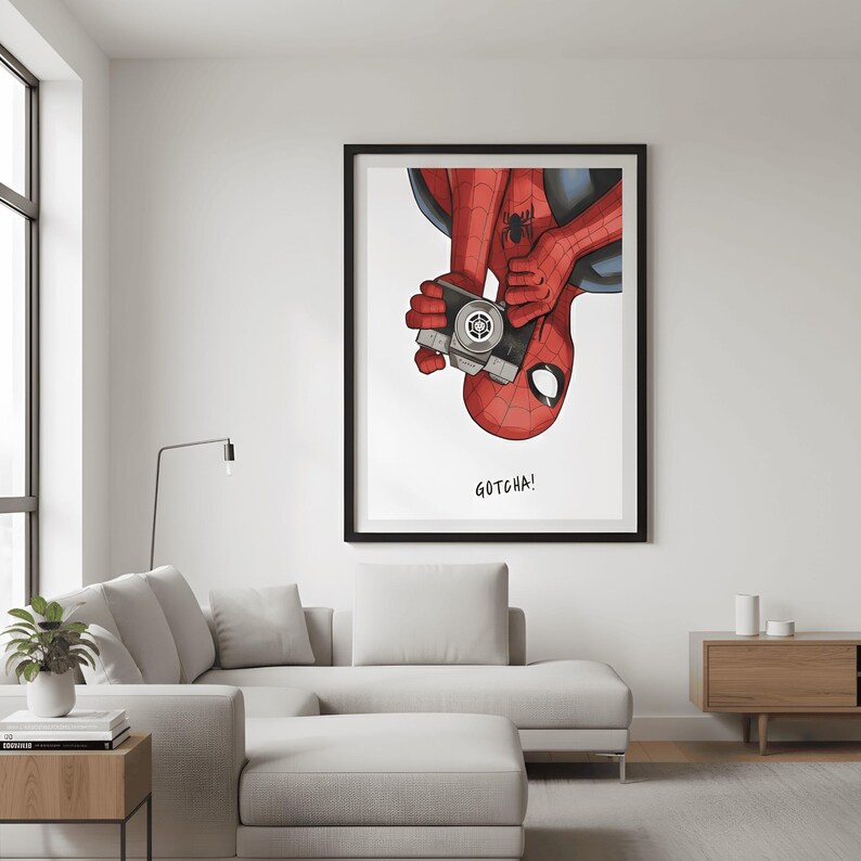 May include: A framed art print featuring Spider-Man holding a vintage camera. The superhero is depicted upside down, with his red and blue suit and mask visible. The text "GOTCHA!" is below the image.