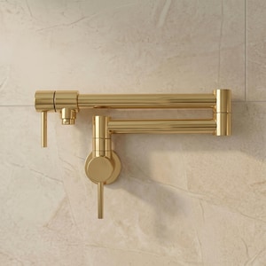 May include: A wall-mounted pot filler faucet with a polished gold finish. This kitchen fixture features a double-jointed articulating arm, a circular base plate, and a single vertical lever handle for water flow control and operation.
