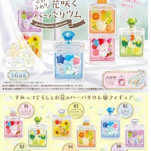 Op de afbeelding: Sumikkogurashi Herbarium figuren in heldere, vierkante flessen met kleurrijke bloemen- en karakterarrangementen. Elke fles heeft een edelsteenachtige stopper. De set bevat zes verschillende ontwerpen, elk met een uniek thema.