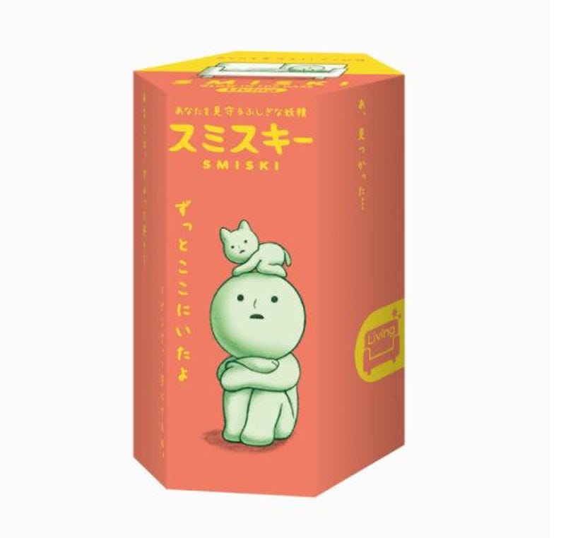 A box with a cartoon character on it, featuring a cat sitting on top of the character.