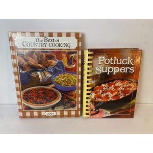 May include: Two cookbooks titled The Best of Country Cooking 2001 and Potluck Suppers. The first book features a brown checkered border and images of fried chicken, salad, and a berry tart. The second book has a yellow spiral binding and a pizza.