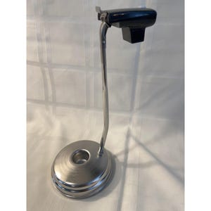 May include: A white ceramic mug with a black handle and the text "But First, Coffee" in a black, bold font. The mug is on a white surface. The mug is 4 inches tall.