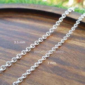 May include: Close-up of two silver-colored chain necklaces. One chain is 3.5 mm thick, and the other is 3 mm thick. The chains are displayed on a wooden surface. The text "poojacraftjewelry" is visible on the surface.