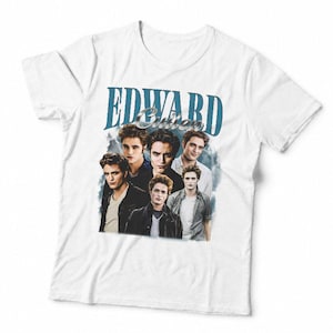May include: A white short-sleeved t-shirt featuring a graphic print of Edward Cullen. The design includes the text "EDWARD CULLEN" in a blue serif font above a collage of multiple photographic portraits of the character in various outfits.