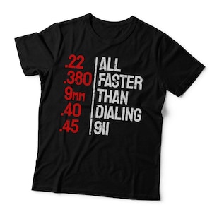 May include: A black short-sleeved t-shirt featuring a graphic print in red and white. The red text lists .22, .380, 9MM, .40, and .45. The white text reads ALL FASTER THAN DIALING 911, separated from the red numbers by a vertical white line.