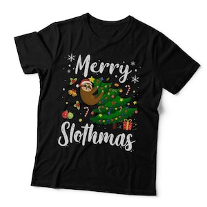 May include: A black short-sleeved t-shirt featuring a graphic of a sloth wearing a Santa hat climbing a decorated Christmas tree. The text Merry Slothmas is printed in white script. The design includes snowflakes, candy canes, and ornaments.