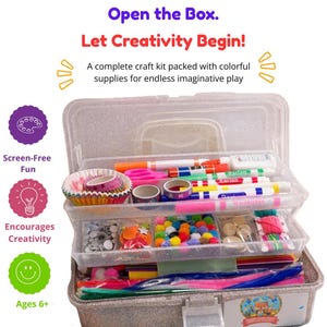 May include: A clear, glittery plastic craft storage box filled with art supplies including markers, glue, scissors, colorful pom-poms, googly eyes, paper cupcake liners, and pipe cleaners. Text reads: Open the Box. Let Creativity Begin!