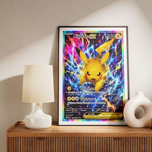 May include: A framed wall art print featuring a Pikachu EX trading card with a vibrant yellow character surrounded by blue and purple lightning effects, rainbow holographic borders, and French text including Chargeur and Tonnerre 170.