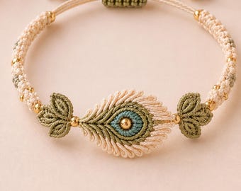 May include: A macrame bracelet featuring a central peacock feather motif in cream, sage green, and teal thread. The design includes small gold-toned metallic beads integrated into the woven band and a sliding knot closure with gold-toned end beads.