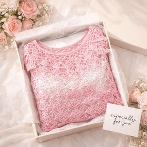 A pink and white ombre crochet top with a floral openwork pattern is folded inside a white gift box with tissue paper and a small card that says "especially for you."