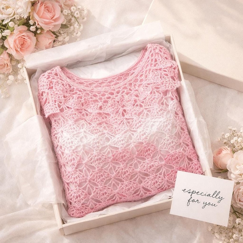 A pink and white ombre crochet top with a floral openwork pattern is folded inside a white gift box with tissue paper and a small card that says "especially for you."