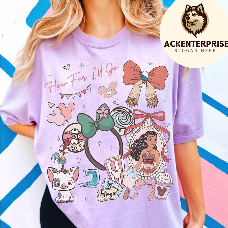 May include: A light purple t-shirt featuring a colorful graphic design with the text "How Far I'll Go". The design includes cartoon characters, bows, and a framed portrait. The shirt has short sleeves.