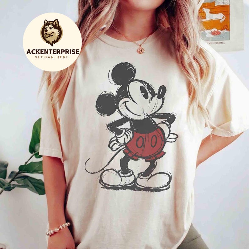 Puede incluir: Camiseta color crema con un gr&aacute;fico desgastado de Mickey Mouse en negro, rojo y blanco. El personaje de dibujos animados est&aacute; de pie con las manos en las caderas. La camiseta tiene un corte holgado y mangas cortas.