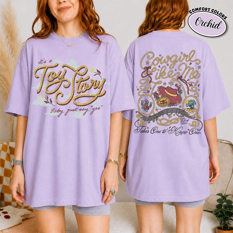 May include: An orchid-coloured t-shirt featuring a front graphic with rope-style text reading "it's a Toy Story Baby, just say yes" and a back graphic with rope-style text "Cowgirl like Me" and "Takes One to Know One" with a cowboy hat.