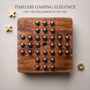 May include: A square wooden board game featuring a grid of holes filled with polished silver metal spheres. The text reads TIMELESS GAMING ELEGANCE 2 IN 1 PEG SOLITAIRE & TIC TAC TOE. Two light-colored wooden X pieces and one O piece are visible.