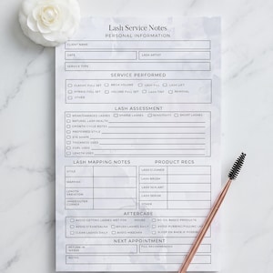 May include: A marble-patterned lash service notes sheet with the text "Lash Service Notes" and "Personal Information." Includes sections for client details, service performed, lash assessment, mapping notes, product recommendations, and aftercare instructions. A rose gold lash wand and a white flower are also in the image.