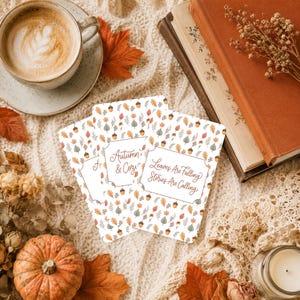 May include: Three rectangular cards featuring a repeating pattern of small autumn leaves and acorns. The central card displays the text Autumn & Cozy, while the right card features the text Leaves Are Falling Stories Are Calling in brown script.