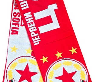 May include: Red and white knitted scarf with the text "ЦСКА СОФИЯ" and "ЧЕРВЕНИ ШАМПИОНИ". The scarf features a star logo and yellow stars. The bottom edge has a fringe.