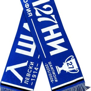 Op de afbeelding: Blauwe sjaal met witte tekst en franjes. De sjaal heeft het woord "Sofia" en het nummer "27". Extra tekst bevat "Levski -1914-" en "Champions -2025/2026-".