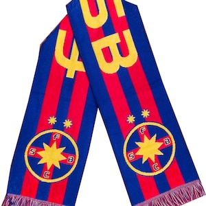 May include: A blue and red striped knit scarf featuring yellow text that reads SB and 4. The scarf displays two circular emblems, each containing a yellow star, the letters F, S, B, C, and two small yellow stars above the circle. The ends have fringe.