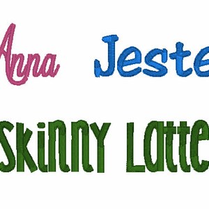 May include: Three lines of machine embroidery text. The top left shows the name Anna in pink cursive script. The top right shows the word Jester in blue block letters. The bottom line shows the words SKINNY LATTE in green block letters.