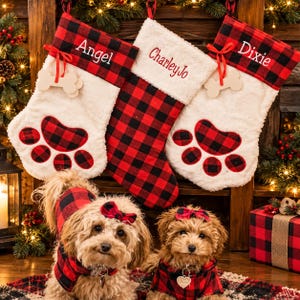 May include: Three Christmas stockings with red and black buffalo plaid cuffs and white faux fur. Two stockings feature paw prints and bone-shaped tags with the names Angel and Dixie. The center stocking is plaid with the name CharleyJo.