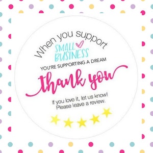 May include: A white circle sticker with pink, blue, and yellow text that says "When you support small business you're supporting a dream thank you". The sticker also has a pink heart and five yellow stars.