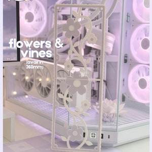 May include: A white computer case with a floral design overlay. The overlay features flowers and vines, with the text "flowers & vines" and "(avail in 360mm)". The case has a clear side panel, revealing internal components.