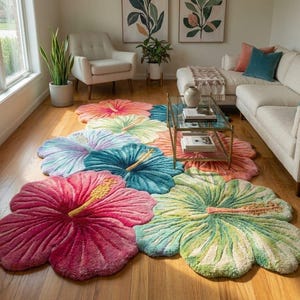 Può includere: Una collezione di tappeti colorati a forma di fiore in varie tonalità di rosa, blu, verde e arancione. Ogni tappeto presenta un design dettagliato dei petali e uno stame giallo, creando una vivace pavimentazione.
