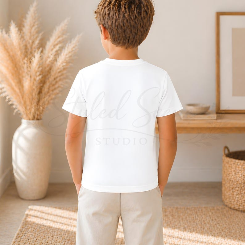 Puede incluir: Una persona lleva una camiseta blanca con el texto "Styled Studio" y pantalones color caqui. Un jarr&oacute;n con plantas secas est&aacute; en el fondo. Vista trasera.