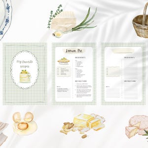 Peut inclure: Illustration &agrave; l'aquarelle d'un livre de recettes et de divers aliments. La couverture du livre de recettes indique "Mes recettes pr&eacute;f&eacute;r&eacute;es" et pr&eacute;sente un g&acirc;teau. Autres &eacute;l&eacute;ments : une assiette, des asperges, des &oelig;ufs, du fromage et une bouteille d'huile d'olive.