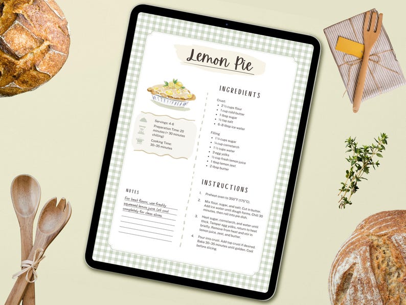 Peut inclure: Une tablette num&eacute;rique affiche une recette de tarte au citron, avec les ingr&eacute;dients et les instructions. Des cuill&egrave;res en bois et une fourchette sont pos&eacute;es &agrave; proximit&eacute;, ainsi qu'un cadeau emball&eacute; et une branche d'herbes. Un pain est visible en arri&egrave;re-plan.