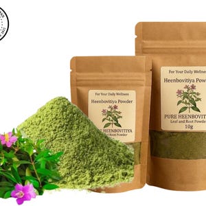 May include: Two brown paper pouches containing Heenbovitiya Powder, labeled with text and a plant illustration. A pile of green powder sits next to a cluster of green leaves with pink flowers. The label reads For Your Daily Wellness Heenbovitiya Powder.