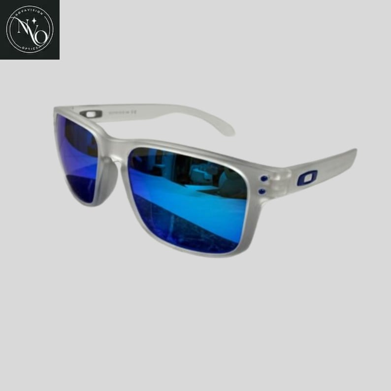 May include: Silver-framed sunglasses with blue mirrored lenses. The sunglasses have a rectangular shape and white arms. The lenses reflect a bright blue color. The frame has a small blue logo on the side.