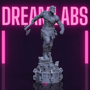 May include: A grey figurine of a muscular warrior with an axe, standing on a rocky base with a rope and chain design. The figure has detailed armour and a beard. The words "DREAM LABS" are in pink above the figure.