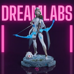Puede incluir: Una figura blanca y azul de una arquera sosteniendo un arco y una flecha, con el texto "DREAM LABS" en rosa. La arquera está de pie sobre una base de piedra con una pequeña criatura. El arco y la flecha son azules.