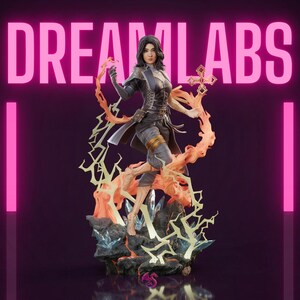 May include: A detailed figurine of a woman in a dark outfit, holding a glowing orange flame and a golden cross-shaped object. The base features crystals and lightning-like accents. The text "DREAM LABS" is displayed in pink.