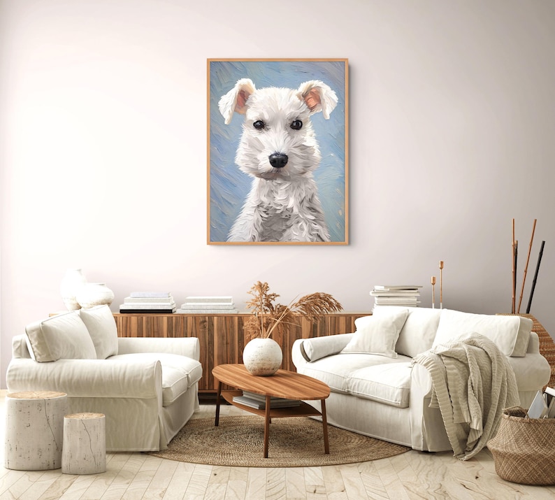 May include: A framed wall art print featuring a portrait of a white dog with textured fur, dark eyes, and a black nose, set against a light blue brushstroke background. The artwork is displayed in a light wood frame on a plain wall.