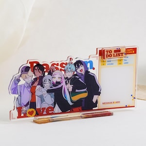 Op de afbeelding: Een helder acryl memobord met een kleurrijke anime-stijl illustratie van een groep mensen. Het bord bevat een "To Do List" sectie en het woord "Love". Twee pennen liggen voor het bord.