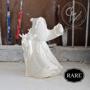 Puede incluir: Figura de cerámica blanca de Papá Noel sosteniendo un reno y una linterna. La figura está hecha en los Estados Unidos por Grapevine Ceramics & Gifts, Hays, KS. La figura está marcada con "RARE".