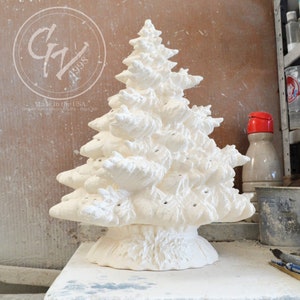 Può includere: Un albero di Natale in ceramica bianca con una superficie testurizzata e fori per le luci. L'albero è su un tavolo con una superficie bianca. Prodotto negli Stati Uniti. Gravydock Ceramics Gifts - Hays, KS