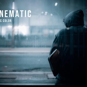 Puede incluir: Una sudadera con capucha oscura usada por una figura vista desde atr&aacute;s, sosteniendo un objeto rectangular. La imagen presenta el texto blanco CINEMATIC ARCTIC COLOR superpuesto sobre un fondo de tonos fr&iacute;os y azulados con una calle urbana borrosa.