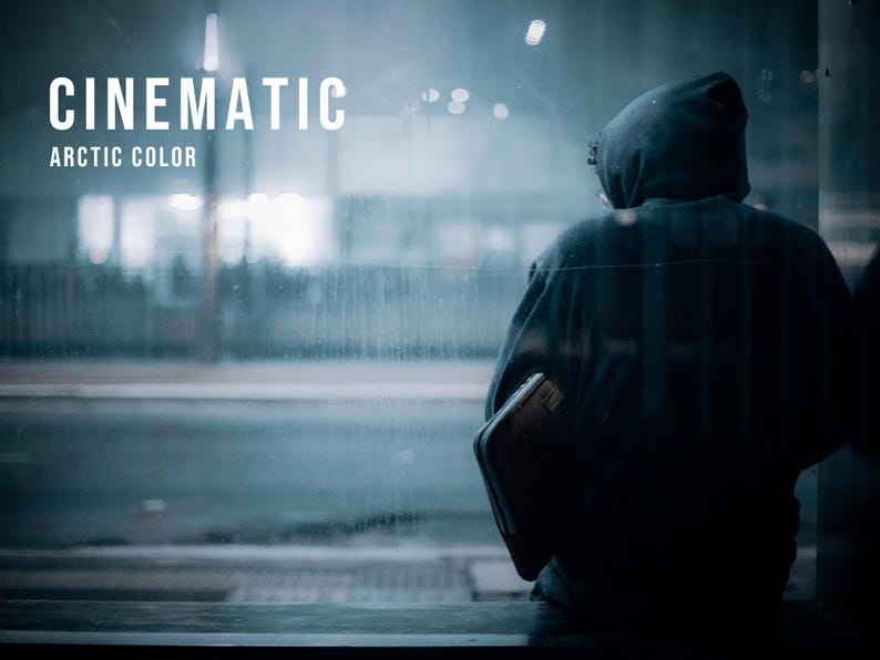 Puede incluir: Una sudadera con capucha oscura usada por una figura vista desde atr&aacute;s, sosteniendo un objeto rectangular. La imagen presenta el texto blanco CINEMATIC ARCTIC COLOR superpuesto sobre un fondo de tonos fr&iacute;os y azulados con una calle urbana borrosa.